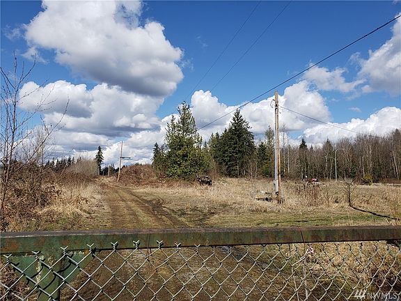 looking north from driveway's gated entrance; hwy 9 is along base of tree line on right in this picture
