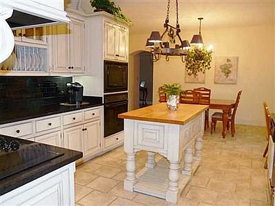 Kitchen. Custom Kitchen with Dining area, Center Island, sleek black granite & black subway tile.