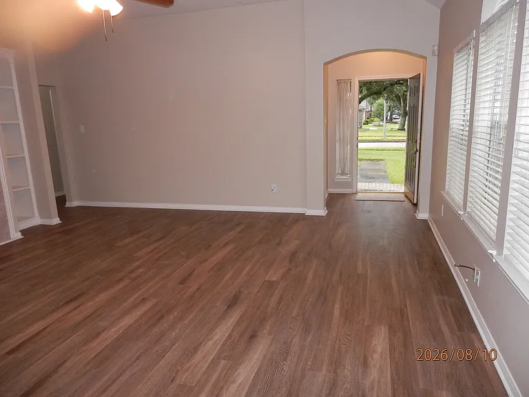 Family room view from kitchen to front foyer. Vinyl plank flooring.