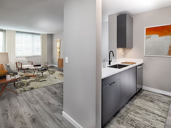 Renovated Package II kitchen, living, and dining areas with hard surface plank flooring