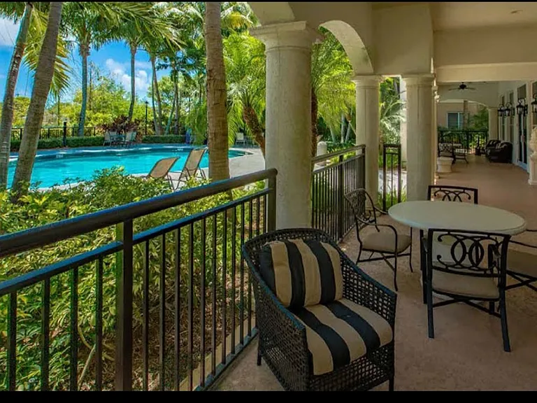 Clubroom Pool and covered patio with ceiling fans, comfy chairs and tables to enjoy a quiet afternoon with friends, have lunch or drinks.