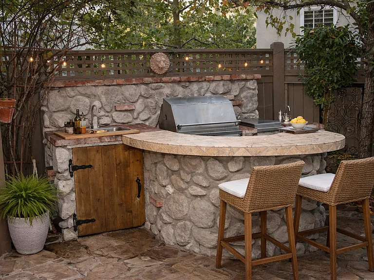 Private outdoor kitchen with built in BBQ and bar seating, perfect for entertaining