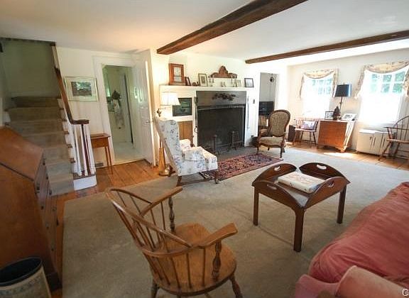 Inviting formal living room with beams, wide board floors, wood