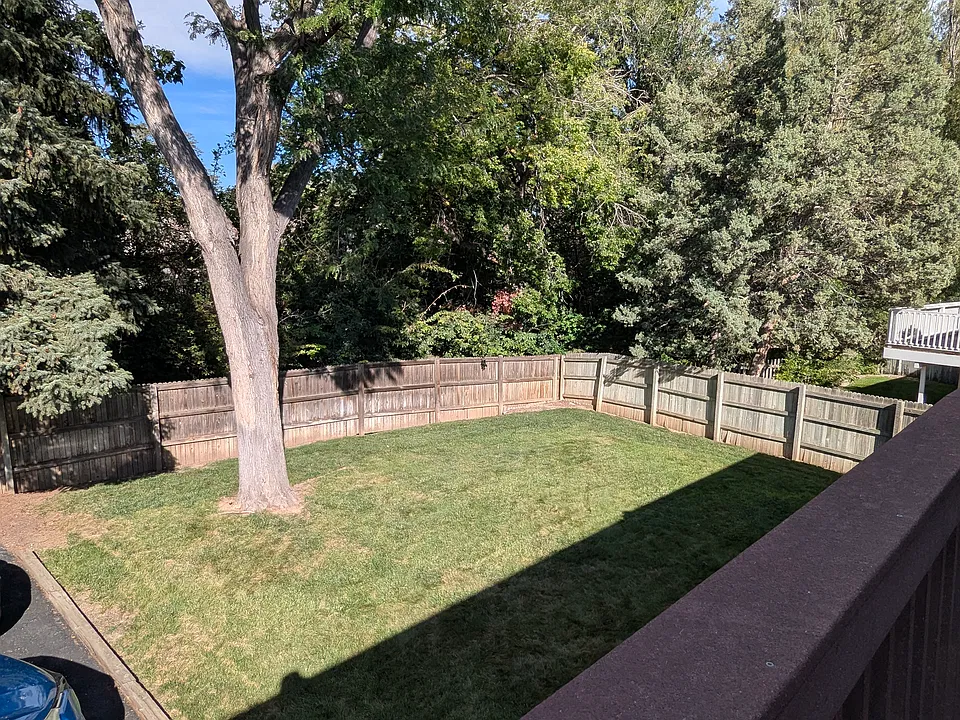 View of the backyard with a wooded area.