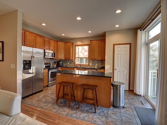 The kitchen with a sliding door to the balcony/deck. Stainless-steel appliances.