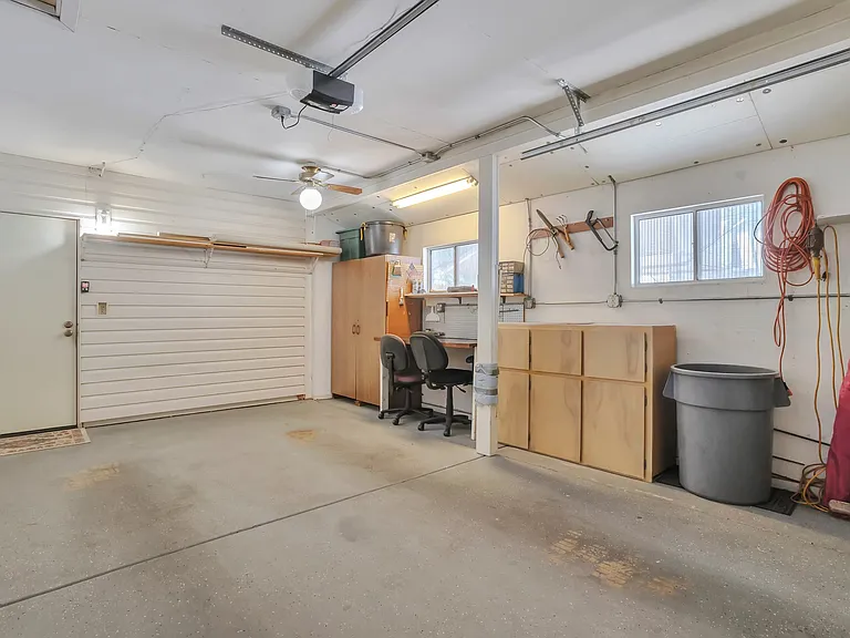 Garage includes a workbench and storage cabinets.