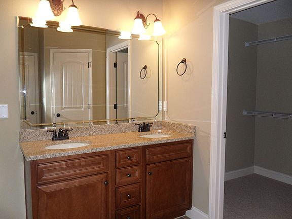 master bath with double vanity and granite tops
