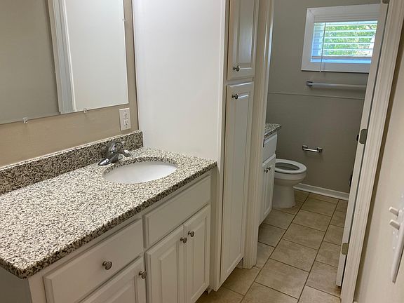 One and a half baths with huge vanity and double granite top sinks, spacious white cabinetry allows for LOTS of linen storage. Tile floors plus new tub surround.