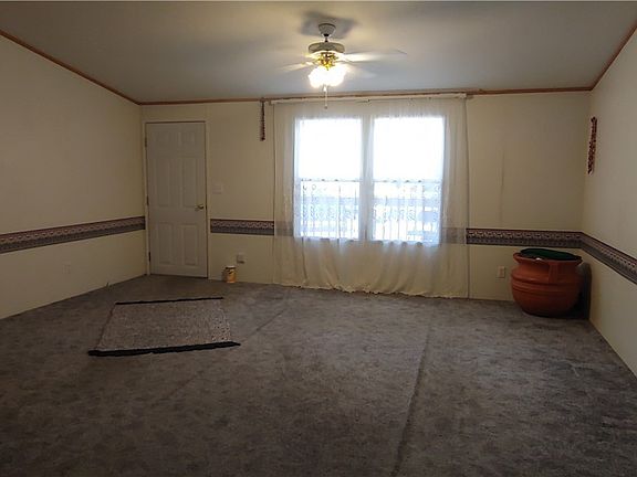 Huge living room looks out to open space past the front covered deck.