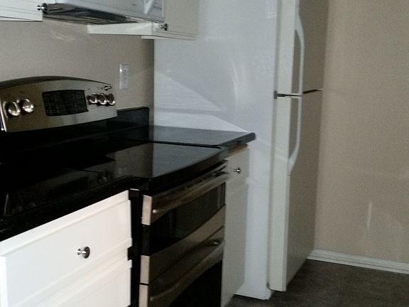 New kitchen with fridge, dishwasher, oven and microwave.
