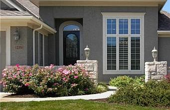 A striking wood door adds a strong architectural statement and an overhang protects from weather.                        
