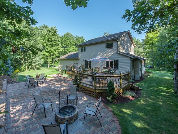 Snapshot of back of house and patio/deck area.    This large paver patio is equipped with a fire pit.   There are many memories to make here with family and friends.The lawn sprinklers help keep the yard green and lush.
