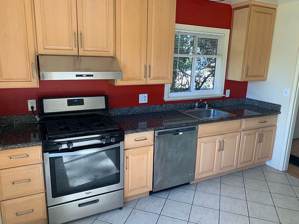 Modern kitchen with granite counters, stainless appliances, and maple wood cabinets