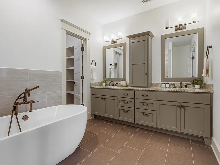 Primary bathroom attaches to the primary suite. Enjoy a double vanity with an extra cabinet for storage, soaking tub, and standing shower.