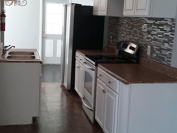 Kitchen with stainless steel appliances: side-by-side refrigerator with ice-maker and electric flat stove top