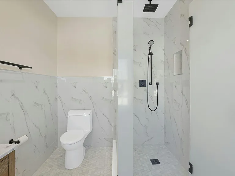 Sun-filled European-style bathroom high ceilings, large shower and towel warmer.