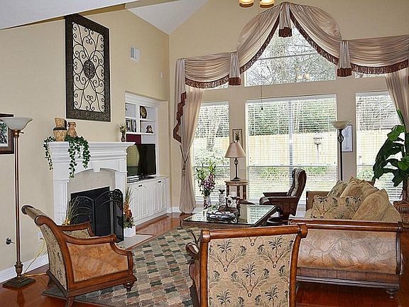 Den with Custom Drapes and Hardwood Flooring