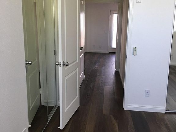 Hallway to second bedroom. Washer and dryer units are in the hallway for easy laundry.