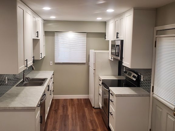 Kitchen and side door. All new cabinets, countertops, tile backsplash. Kitchen includes electric stove/oven, dishwasher, microwave, fridge, large double sink with garbage disposal.