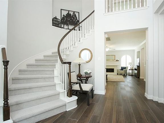 Upon entry you will be immediately impressed by the dramatic tall ceilings, curved stairway, and the nice flow created by the wood-look tile and open spaces.
