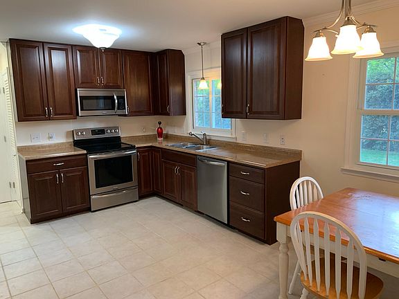 Eat in Kitchen with cherry cabinets, stainless steal appliances, title flooring. Table and chairs not included.