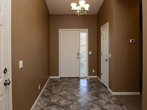 Entryway with tile floor and coat closet.