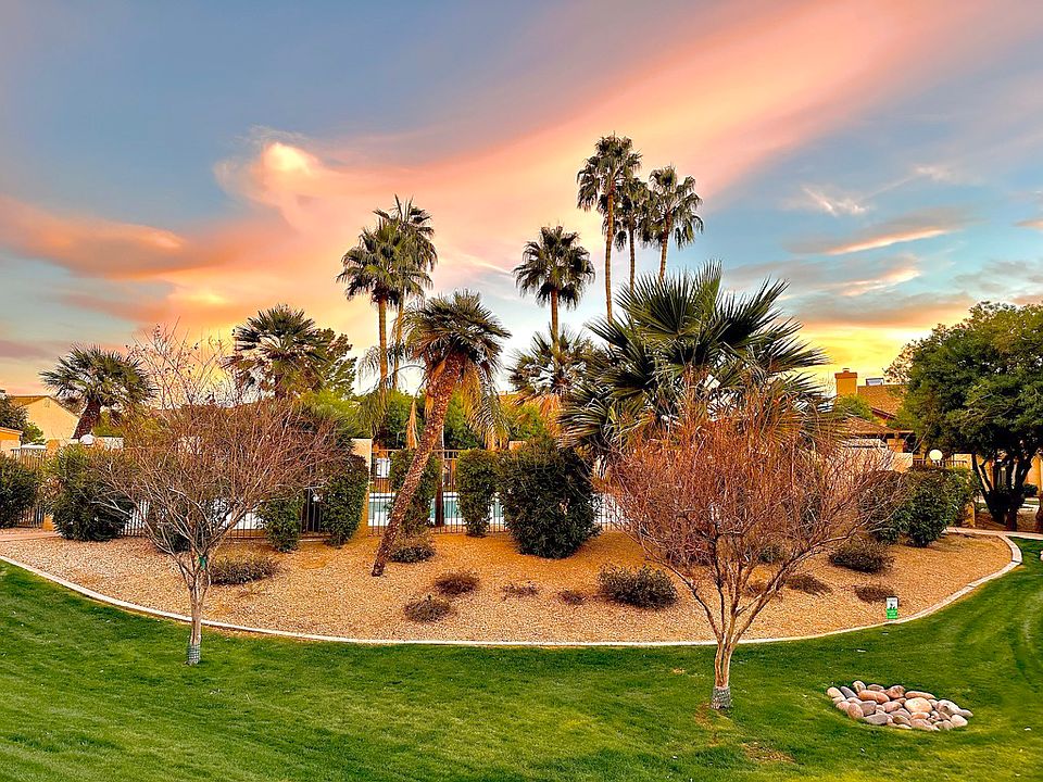 Center of complex with beautiful palms, grass and large pool and sitting area.
