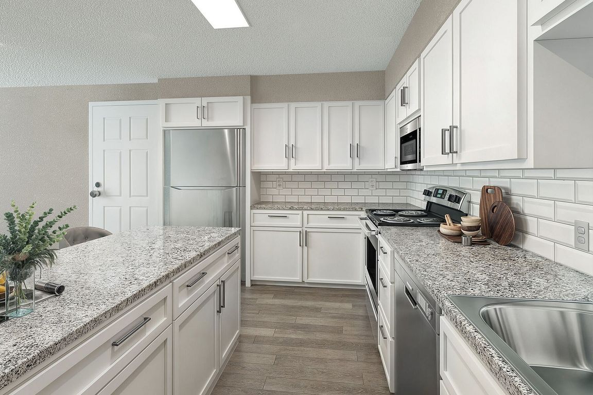 Kitchen with granite counters, stainless appliances, and modern cabinetry