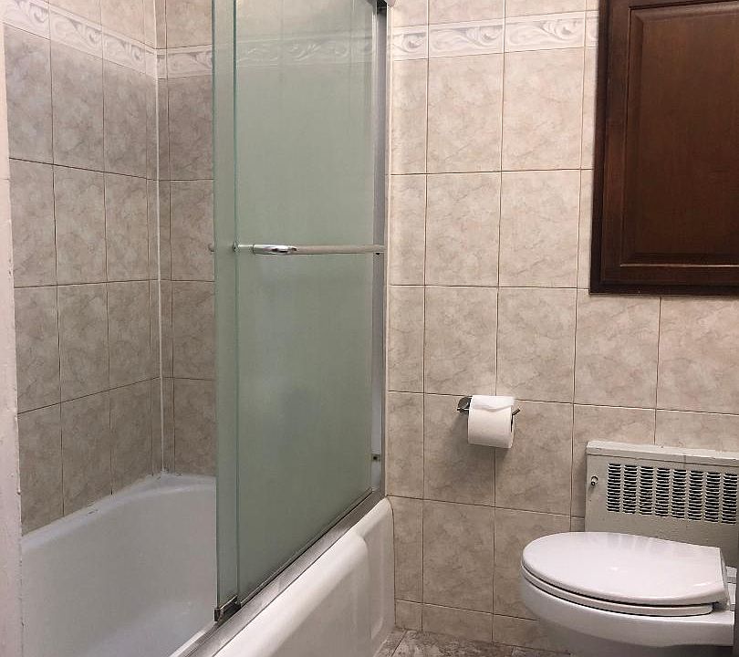 Shower with sliding doors, and tub.