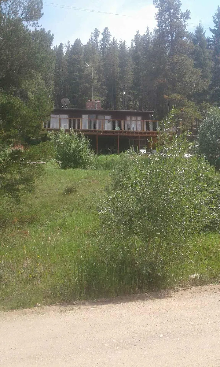 A view of the house on the hill above the road overlooking the water. - 412 Pactolus Lake Rd