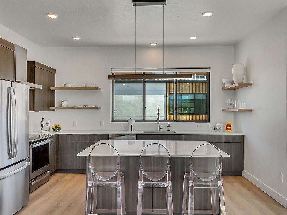 Kitchen with stainless steel finishes, open shelves, modern cabinets, and breakfast bar
