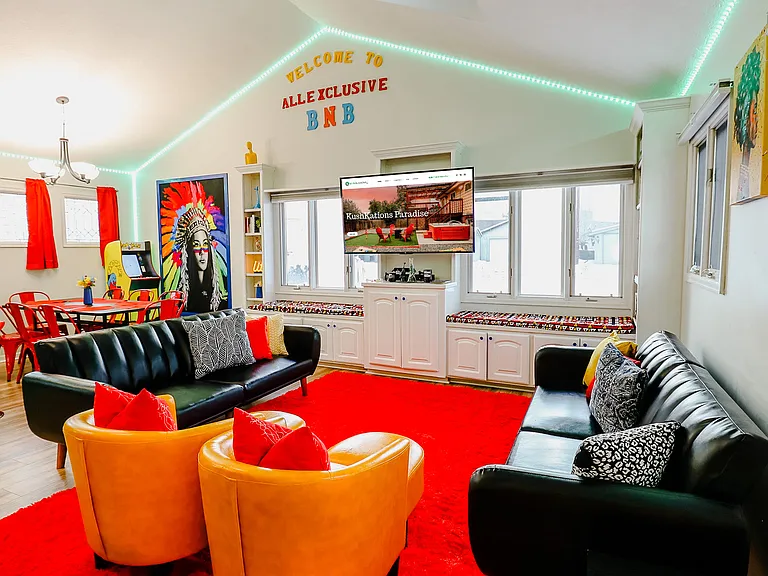 A vibrant orange couch paired with a sleek black couch, creating a bold and stylish seating arrangement that stands out in any living space.