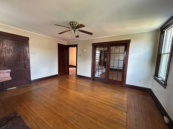 View from porch door into full living room. Dining room beyond glass doors, to left, entry closet and bedroom one.