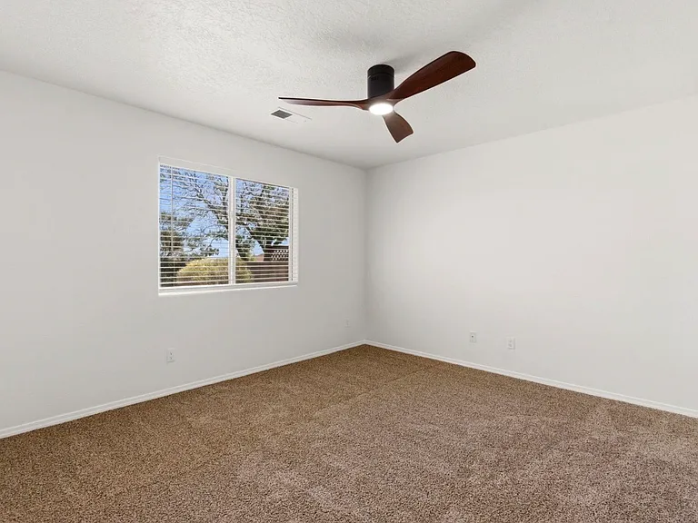 Master bedroom overlooking backyard with new ceiling fan