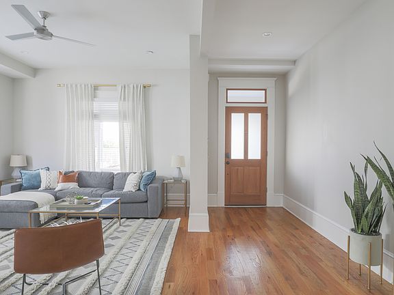 Spacious front entryway opens to light-filled living room, wood floors throughout