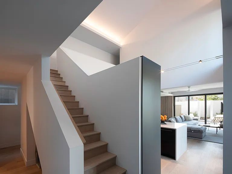 A light-filled arrival with clean lines, warm wood flooring, and architectural volume immediately sets the tone for the home.