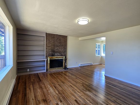 Bright and open living room with fireplace and built in bookcase. Newer double paned windows throughout.