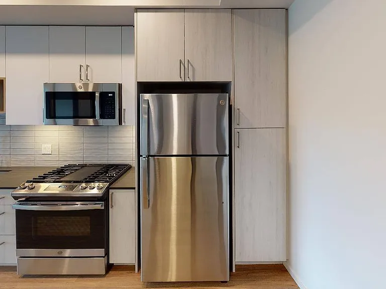 Premium kitchen finishes include pull-down kitchen faucets, black granite countertop sinks, white subway tile and modern chrome pulls