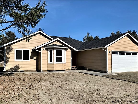 Front view from an angle that shows off concrete sidewalk that goes from entry to front porch and wraps around the front bay window, to the side and then all the way to the large back patio!