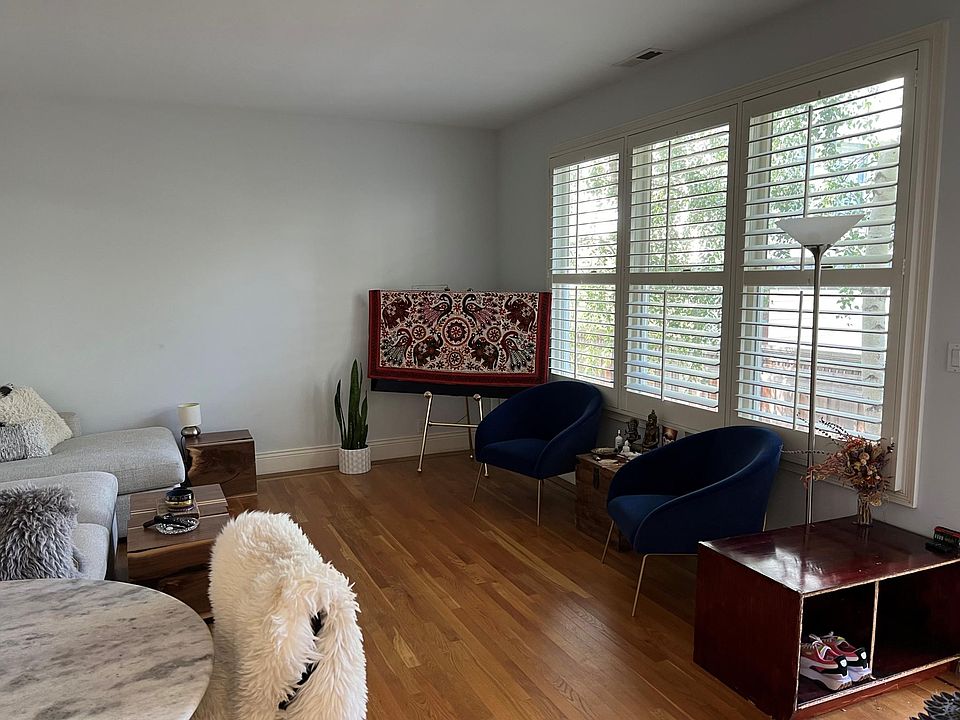 Alternate view of cottage living room showing windows to private gated courtyard.