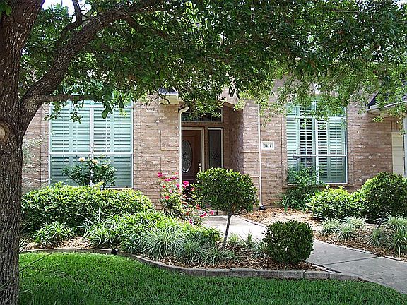 Lovely mature trees frame the front entrance.