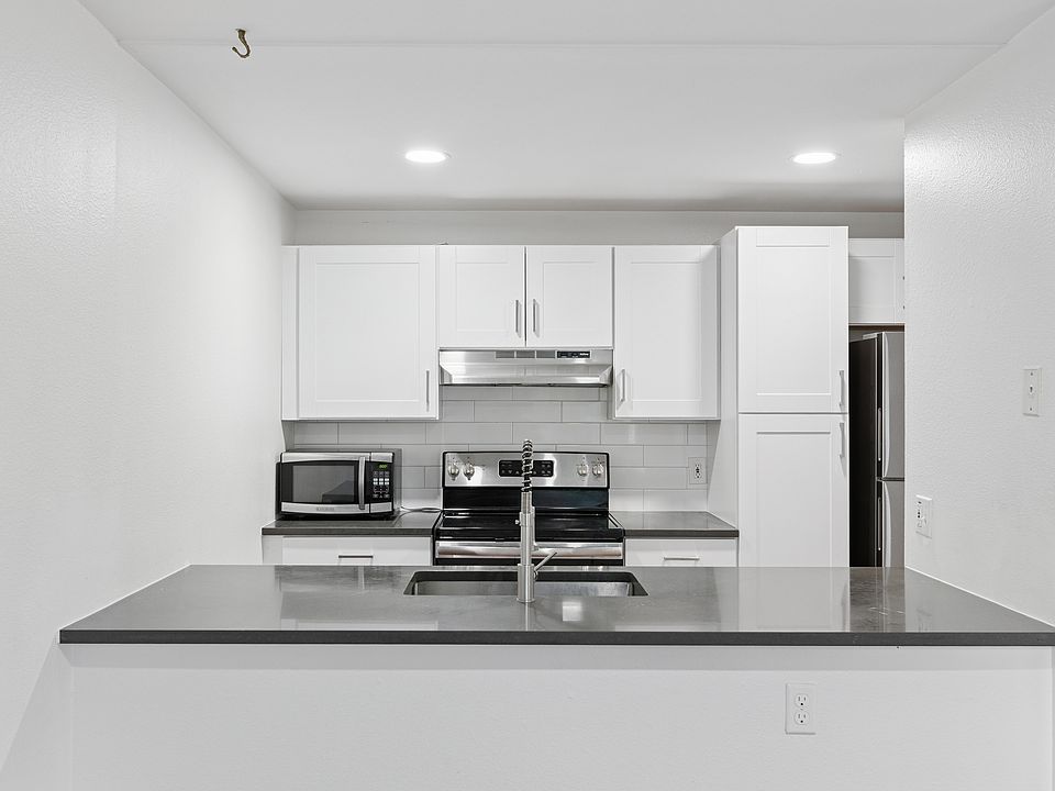 Fully renovated kitchen with thick-slab granite and custom pull-out cabinets