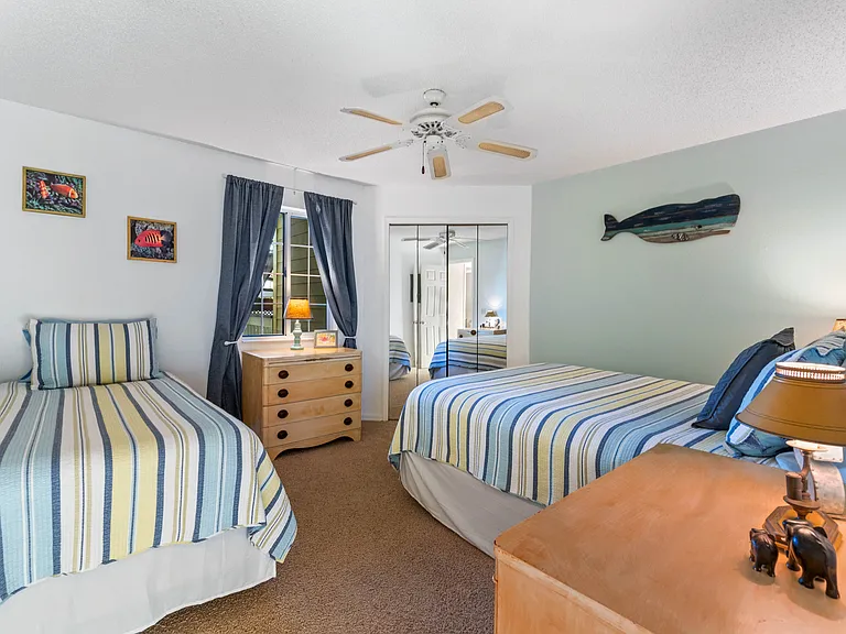 Large guest bedroom with a queen-size bed as well as a twin-size bed. The guest bedroom features a large walk-in closet as well as a privacy door that allows guests to have an en-suite bathroom.