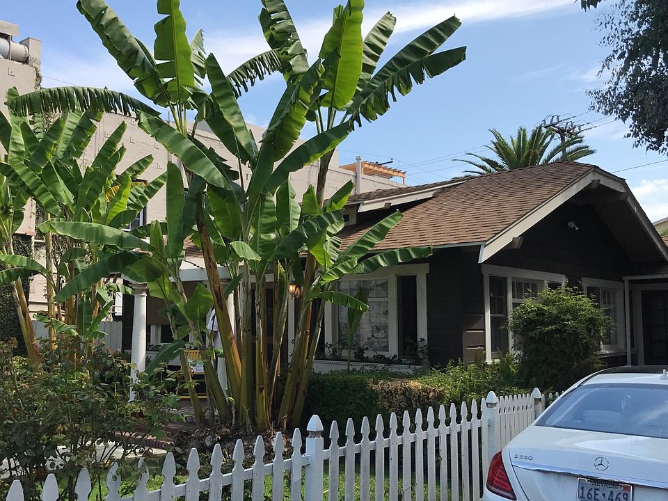 Front of house, shows fenced yard and offstreet parking for multiple cars.