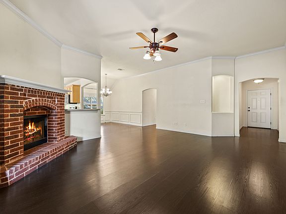 Spacious living area filled with natural light, a cozy fireplace, and beautiful wooden floors.