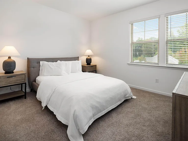 Secondary bedroom with queen size bed and large window letting in a ton of natural light.