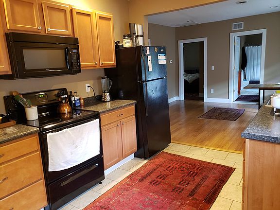 Kitchen with view of dining room. Equipped with dishwasher, microwave, stove and refrigerator.