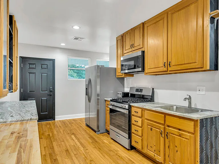 Contemporary kitchen area with sleek counter tops, ample cabinet storage, and essential appliances!!