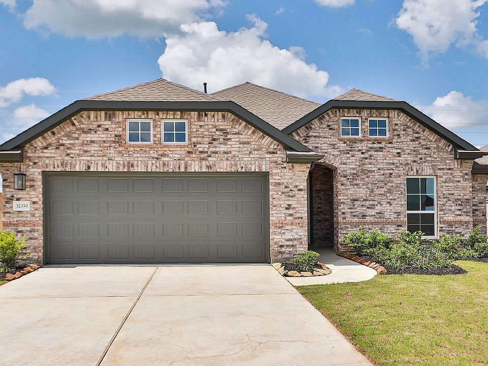 Sophisticated brick facade with double garage and lush landscape in prestigious Oakwood Estates.