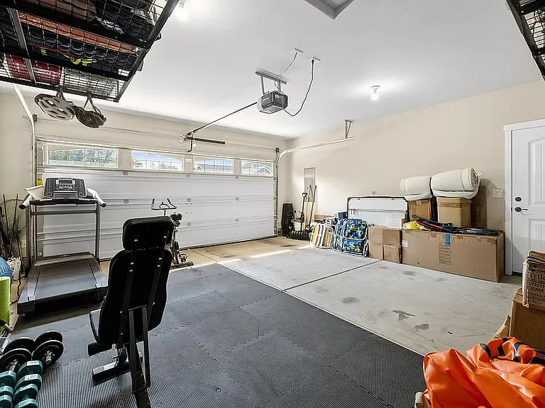 Roomy 2 car garage with storage and workshop area complete with a sink.